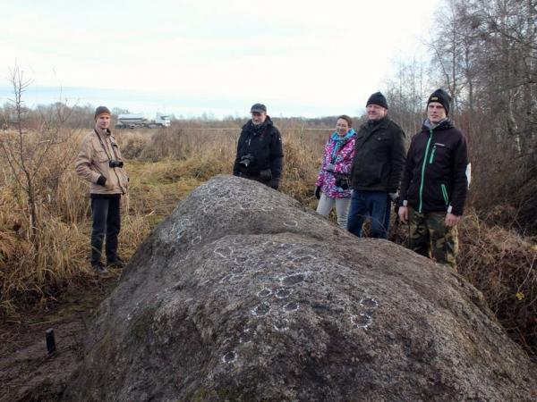 LPC ekspedīcija kopā ar grobiņiešiem pie izcilā atklājuma. Aļļupītes 1.bedrīšakmens šobrīd ir 8 bedrītēm bagātākais senais kulta akmens Latvijā. Andra Grīnberga foto.